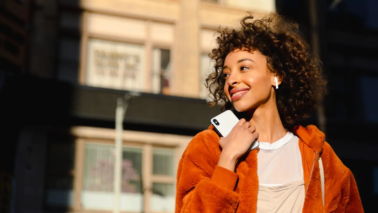 Mulher usando smartphone com PayzuCell - Conectividade móvel integrada